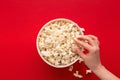 Bucket of popcorn on red background, top view Royalty Free Stock Photo