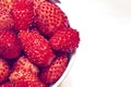 Bucket with red wild strawberry on white background