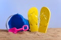 Bucket, shovel and flipflops on the beach Royalty Free Stock Photo