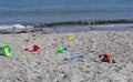 Bucket spade sandcastle Diggers toys on sandy beach with sea wave in UK