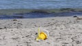 Bucket spade sandcastle Diggers toys on sandy beach with sea wave in UK