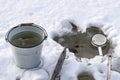 Bucket with water in the cold on the white snow