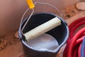 A bucket with white paint and a roller on an apartment is under construction Royalty Free Stock Photo