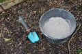 bucket of wood ash together with a shovel on arable soil. use of fertilizer and insecticide