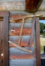 Bucksaw hanging outside of old log cabin