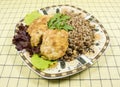 Buckweat with chicken chops amd green salad in the plate