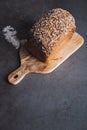 Buckwheat bread with multi seeds on wooden table. Vertival picture. Blogging concept