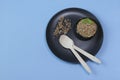 Buckwheat grains on black plate and buckwheat in a bowl, blue background. Gluten free grain for healthy diet. Top view Royalty Free Stock Photo