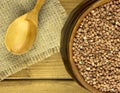 Buckwheat groats in a bowl and wooden scoop