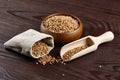 Buckwheat whole grains scattered on wooden background. Healthy breakfast food Royalty Free Stock Photo