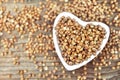 Buckwheat in heart-shaped bowl, gluten free ancient grain for healthy diet