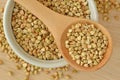 Buckwheat kernels in wooden spoon and bowl