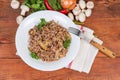 Buckwheat porridge with mushrooms on dish, fork, ingredients, top view Royalty Free Stock Photo