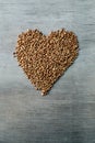 Buckwheats grains formed in heart shape on wooden background Royalty Free Stock Photo