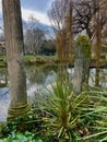 Bucolic scene in Parc Monceau, between two imitation Roman columns over pond. Paris, France