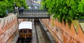 Buda castle fanicular tram mving under a bridge. A could standing in rain with an umbrella Royalty Free Stock Photo