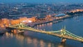 Budapest city at blue hour with illuminated Liberty bridge on Danube River, picturesque evening cityscape.