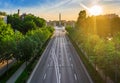 Budapest, Hungary - Aerial drone view of totally empty Andrassy street at sunrise with green trees and sunlight and Heroes` Square