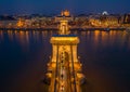 Budapest, Hungary - Aerial view of the beautiful illuminated Szechenyi Chain Bridge over River Danube at blue hour with St. Stephe Royalty Free Stock Photo