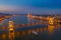 Budapest, Hungary - Aerial view of the famous illuminated Szechenyi Chain Bridge at blue hour with sightseeing boat Royalty Free Stock Photo