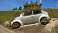 Old vw beetle car also known in part of world as bug parked planted many colorful flowers Royalty Free Stock Photo