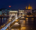 Budapest, Hungary - Blood Moon rising over downtown of Budapest with beautiful Szechenyi Chain Bridge and St. Stephen`s Basilica Royalty Free Stock Photo