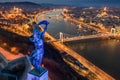 Budapest, Hungary - Blue illuminated Hungarian statue of liberty on World Autism Awareness Day with skyline of Budapest Royalty Free Stock Photo