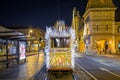 Budapest, Hungary - Festively decorated light tram Fenyvillamos on the move at Fovam Square with the Great Market Hall