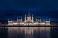 Budapest, Hungary - Illuminated Hungarian Parliament building with blue cloudy sky and reflection on River Danube Royalty Free Stock Photo