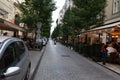 Budapest / Hungary - July 29 2019: Small street with pavement in Budapest with restaurants and a motorbike.People sitting dining