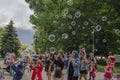 Budapest, Hungary - July 13, 2019 Young childrens are playing with colourful soap bubble in a outdoor park with family during the Royalty Free Stock Photo