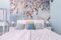 Budapest, Hungary - June 10, 2019: Detail shot of bedroom with modern stylish spring birds theme wallpaper, colorful pillows and
