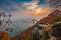 Budapest, Hungary - Lookout on Gellert Hill with Liberty Bridge Szabadsag Hid, fog over River Danube, colorful sky and clouds Royalty Free Stock Photo