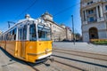 BUDAPEST, HUNGARY - MARCH 30, 2019: Old yellow tram speeds up along city streets. The historical center of the capital of Hungary Royalty Free Stock Photo