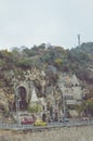 Budapest, Hungary - Nov 6, 2019: Gellert Hill Cave Church, Sziklatemplom. Liberty Statue on the top of the hill. Cars on the road