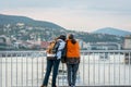 Two woman talking and leaning against a steel railing on a bridge in Budapest Hungary.