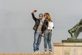 Young caucasian tourist couple wearing sunglasses standing on high ground taking a selfie.