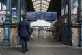 Railway staff ticket inspector from Mav start standing in front of the departures board of main platform of the Budapest Nyugati