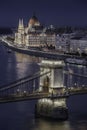 Budapest, Hungary - The world famous illuminated Szechenyi Chain Bridge with the Parliament of Hungary and sightseeing boat Royalty Free Stock Photo