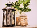 Buddah statue in modern home, Home decoration. Candle Lighter and Buddha Head statue and Monstera's Leaves. Holidays decoration Royalty Free Stock Photo