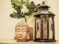 Buddah statue in modern home, Home decoration. Candle Lighter and Buddha Head statue and Monstera's Leaves. Holidays decoration Royalty Free Stock Photo