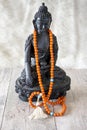 Buddah statue with orange beads for reading mantras Royalty Free Stock Photo