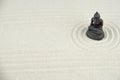 Buddha and abstract Zen drawing on white sand. Concept of harmony, balance and meditation, spa, massage, relax. Zen garden Royalty Free Stock Photo