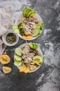 Buddha bowl with chicken meat, bulgur, white beans, quinoa, avocado, lemon and fresh cucumber. Vertical shot