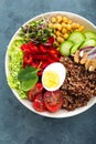Buddha bowl dish with boiled egg, chickpea, fresh tomato, sweet pepper, cucumber, savoy cabbage, red onion, green sprouts, spinach Royalty Free Stock Photo