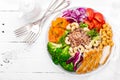 Buddha bowl dish with chicken fillet, brown rice, pepper, tomato, broccoli, onion, chickpea, fresh lettuce salad, cashew and walnu Royalty Free Stock Photo