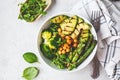 Buddha bowl with grilled avocado, asparagus, chickpeas, pea sprouts and broccoli