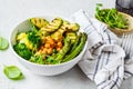 Buddha bowl with grilled avocado, asparagus, chickpeas, pea sprouts and broccoli