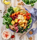 Buddha bowl of mixed vegetables,tofu cheese and groats. Healthy and nutritious vegan meal.