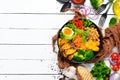 Buddha bowl: pumpkin, broccoli, egg, tomatoes, carrots, paprika in a black plate on a white wooden background. Royalty Free Stock Photo